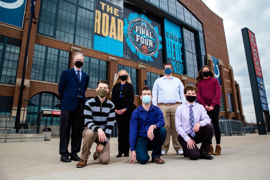 Picture of five journalism students and two professors in front of Lucas Oil Stadium