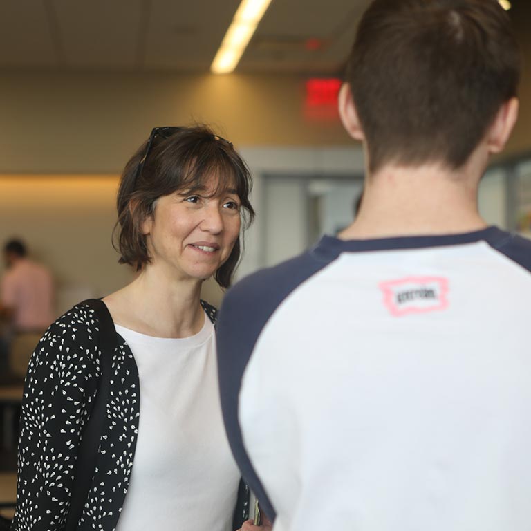 A woman talks with a student.