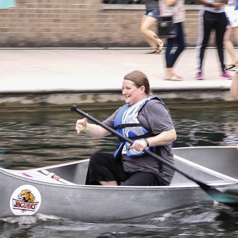 A woman in a canoe paddles.   