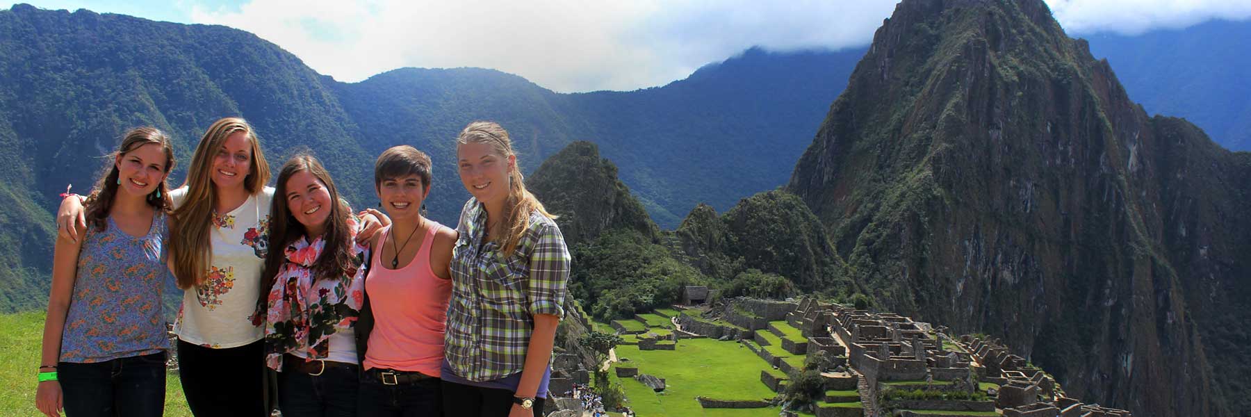 Female students stand in front of Machu Picchu.