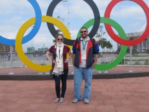 Rebecca Harris (left) and Frank Gogola in front of the Olympic Rings at the Barra Olympic Park in Rio de Janeiro.
